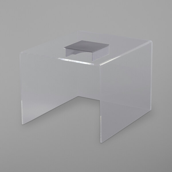 A clear acrylic table with a clear plastic box on top with silver edges.
