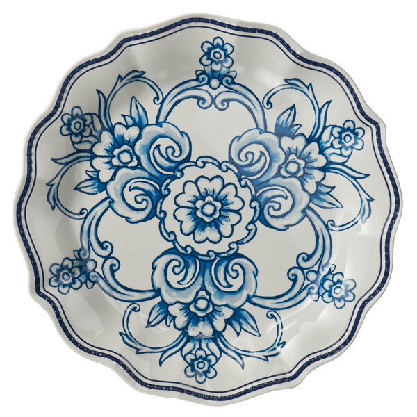 A white American Metalcraft melamine plate with a blue and white floral design and scalloped rim.