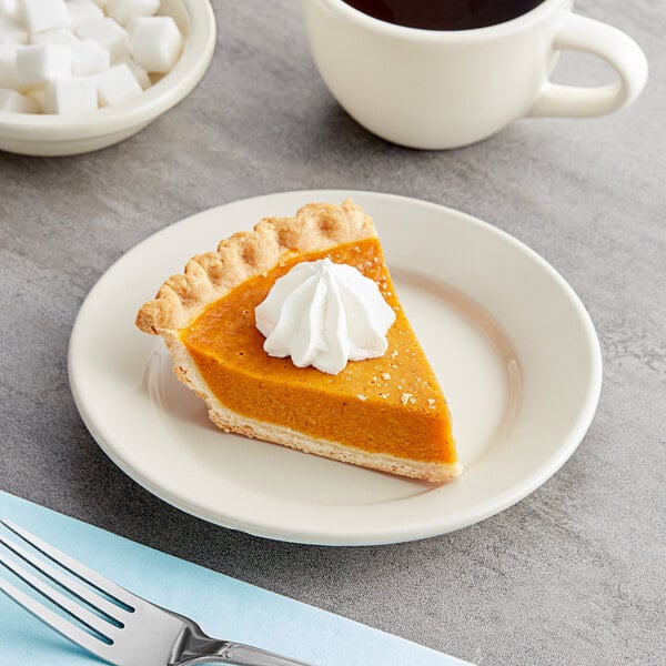 An Acopa ivory stoneware plate with a slice of pumpkin pie and a cup of coffee.