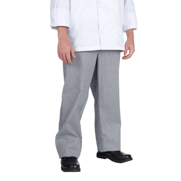 A person wearing a white chef coat and houndstooth chef trousers.