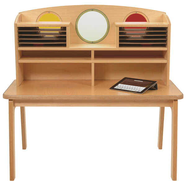 A Whitney Brothers children's wood desk with a tablet and a shelf.