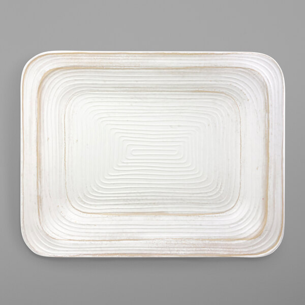 An off white rectangular melamine serving dish with a wavy design.