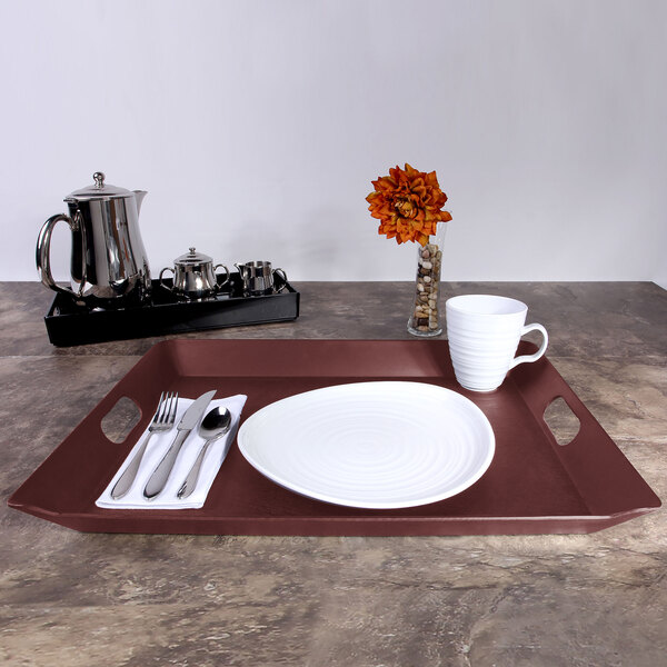 An Elite Global Solutions mahogany woodgrain rectangular room service tray with a plate, silverware, and a white mug on it.
