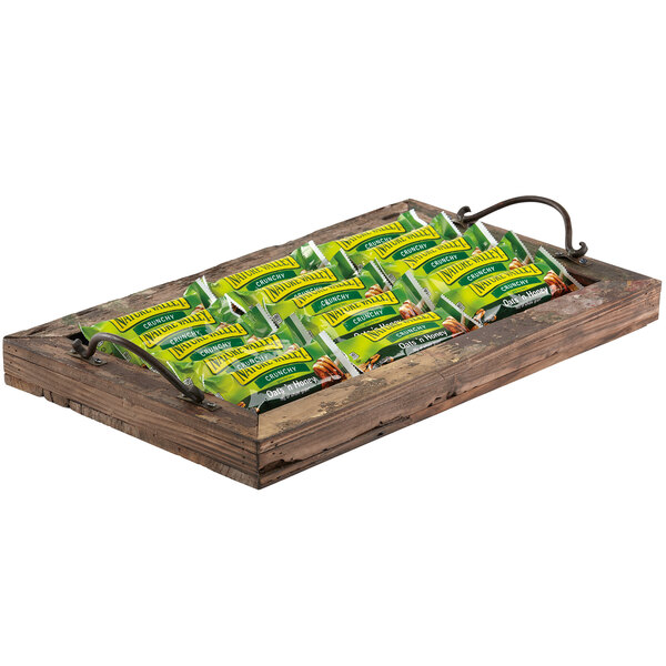 A GET reclaimed wood rectangular serving tray with a bunch of crunchy snacks in green and yellow packages.