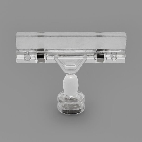 A clear plastic object with a white base holding a clear glass container with a white cap.