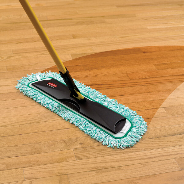 A Rubbermaid green microfiber fringed dust mop pad on a wood floor.