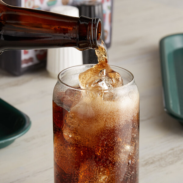 A Reading Soda Works Cola bottle pouring soda into a glass with ice.