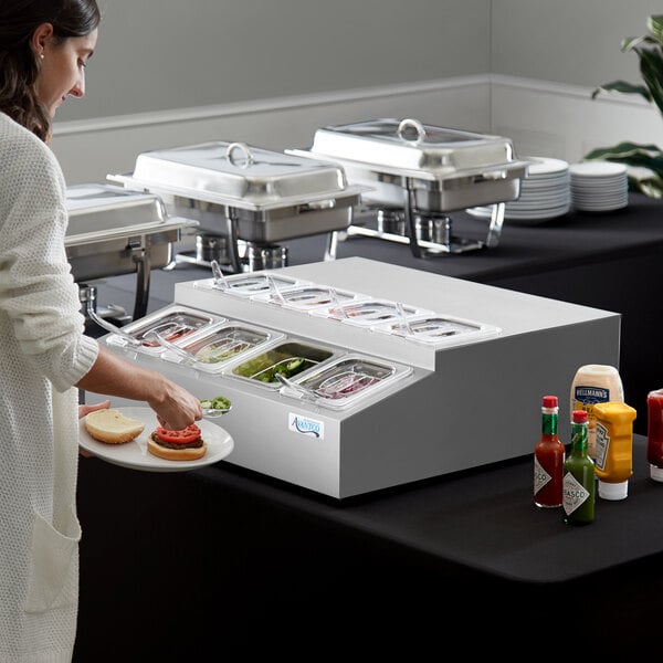 An Avantco refrigerated countertop prep rail on a hotel buffet counter with food in white plates.