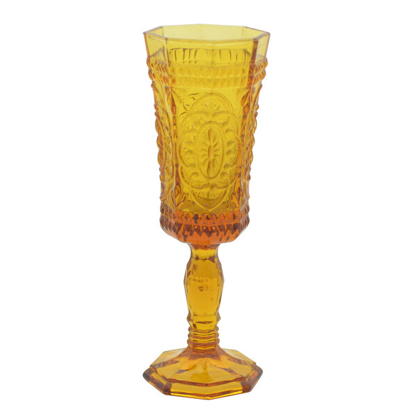 A yellow 10 Strawberry Street Vatican champagne flute with a design on it.