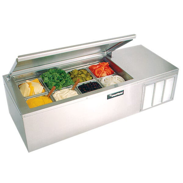 A Delfield countertop refrigerated prep rail with lettuce, tomatoes, and various food containers inside.