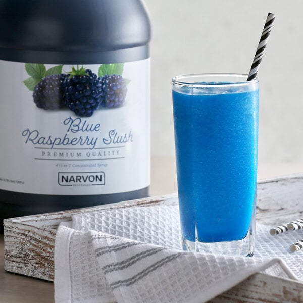 A blue drink in a glass with a straw and blue liquid made with Narvon Blue Raspberry Slushy Concentrate.