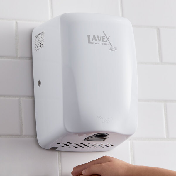 A white Lavex stainless steel automatic hand dryer on a white tile wall.