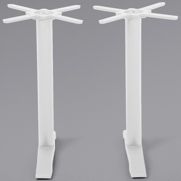 A pair of white metal BFM Seating Bali end table bases with two legs on each.