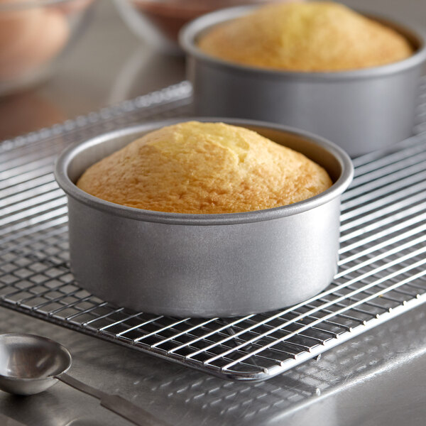 Two Chicago Metallic round cakes on a cooling rack.