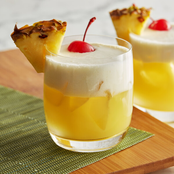 A glass of yellow DaVinci Pina Colada with a cherry on top.