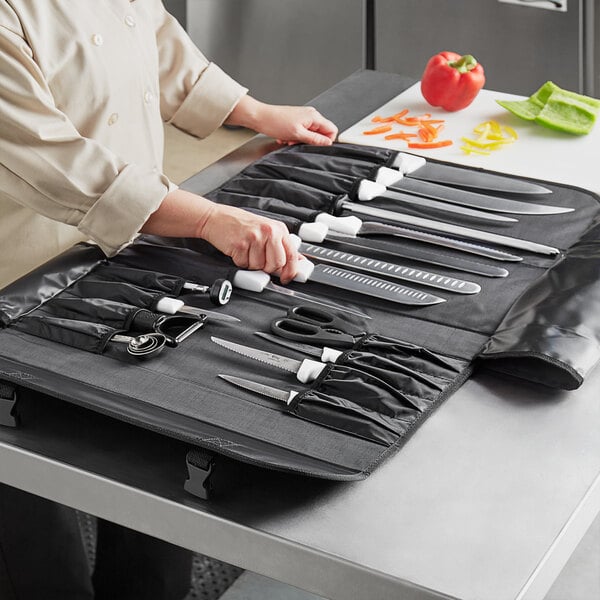 A person cutting a red bell pepper with a Choice 18 piece knife set.