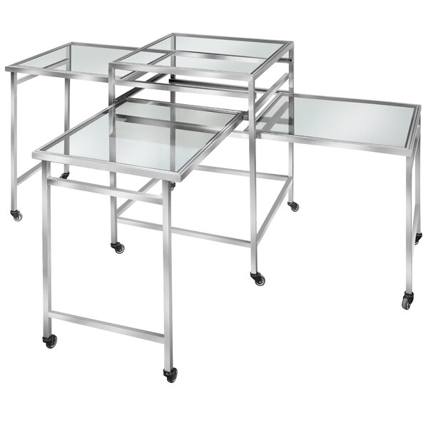 Three Eastern Tabletop square glass rolling banquet tables on a table with wheels.