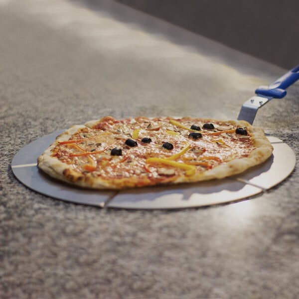 A pizza being cut on a GI Metal aluminum 6 portion pizza tray with a blue handle.