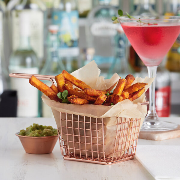 A rose gold rectangular mini fry basket filled with fries and a drink.