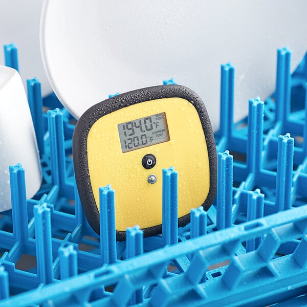 A yellow digital Taylor TempRite dishwasher plate thermometer on a dish rack.