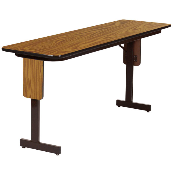 A Correll rectangular seminar table with a medium oak finish and a black panel leg frame.