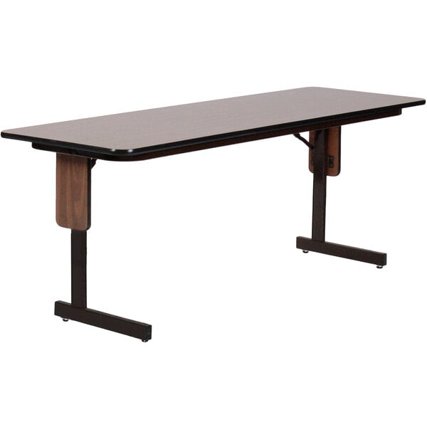 A rectangular Correll seminar table with a walnut finish and black panel legs.