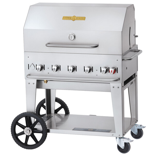A stainless steel Crown Verity mobile outdoor grill with wheels and knobs.