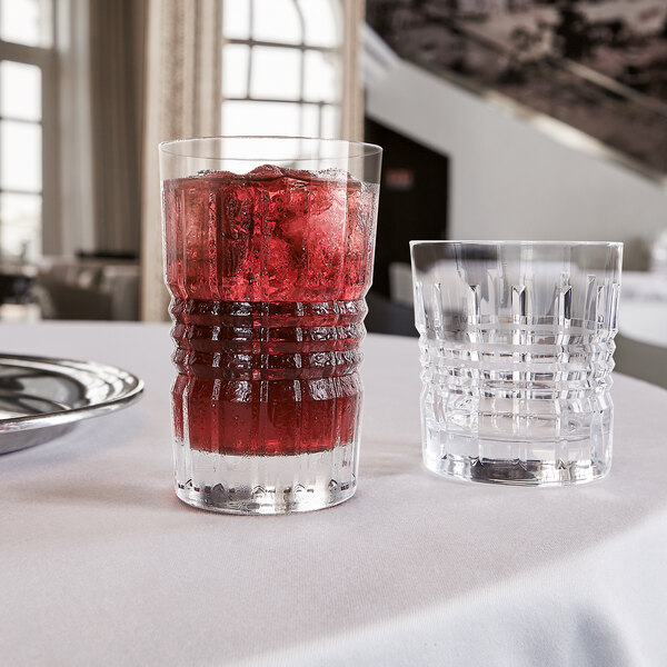 Two Chef & Sommelier highball glasses filled with red liquid on a table.