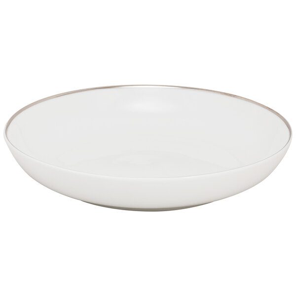 A white porcelain soup bowl with a silver rim.