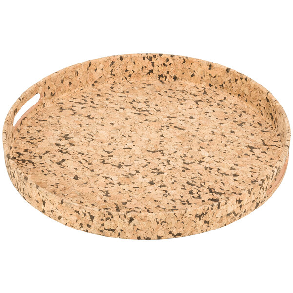 A round cork serving tray with black specks.