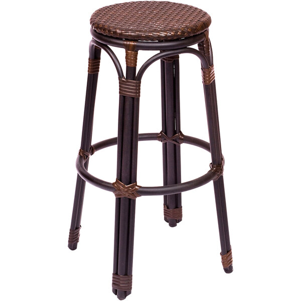 A brown synthetic wicker BFM Seating Marina bar stool on a table.