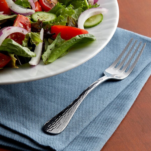 A plate of salad with a fork.