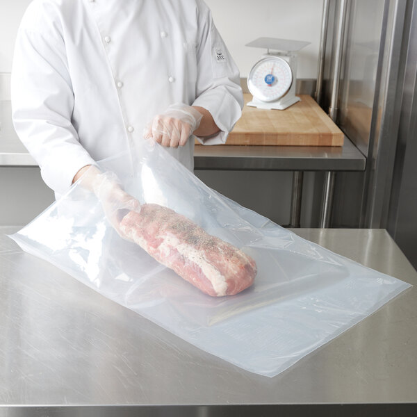 A chef using ARY VacMaster vacuum packaging bags to wrap a piece of meat.
