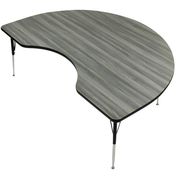 A Correll Kidney-shaped activity table with metal legs and a New England driftwood finish.