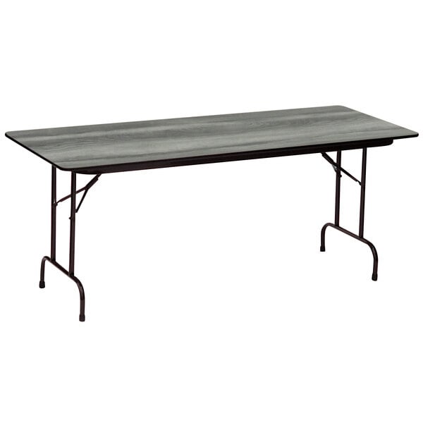 A Correll rectangular folding table with a New England driftwood finish top and black legs.