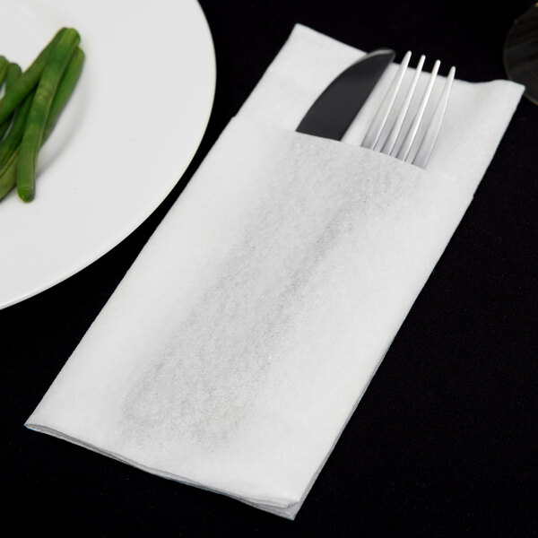 A fork and knife on a white Hoffmaster Quickset linen-like dinner napkin.