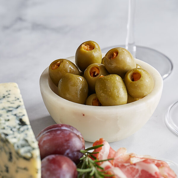 A bowl of Belosa habanero pepper stuffed green olives and cheese on a table.