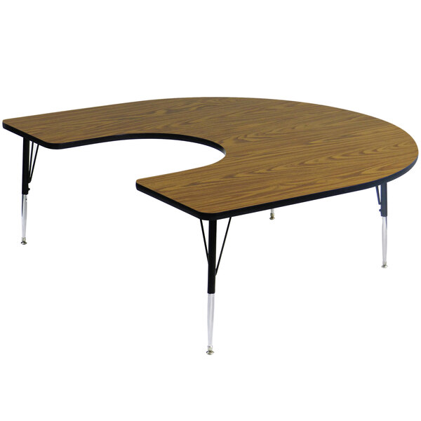 A Correll medium oak horseshoe-shaped activity table with adjustable legs.