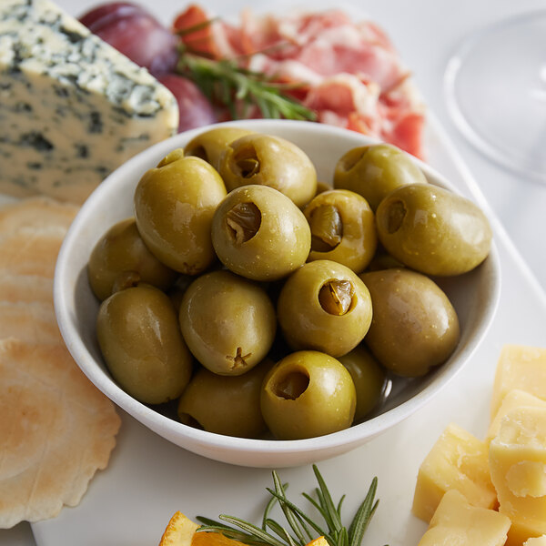 A white plate with Belosa jalapeno stuffed green olives and cheese.