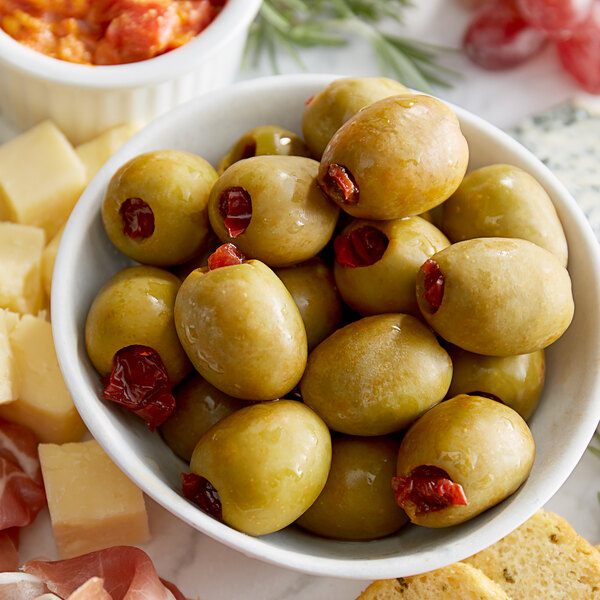 A bowl of Belosa Chipotle Pepper Stuffed Queen Olives and cheese on a table.