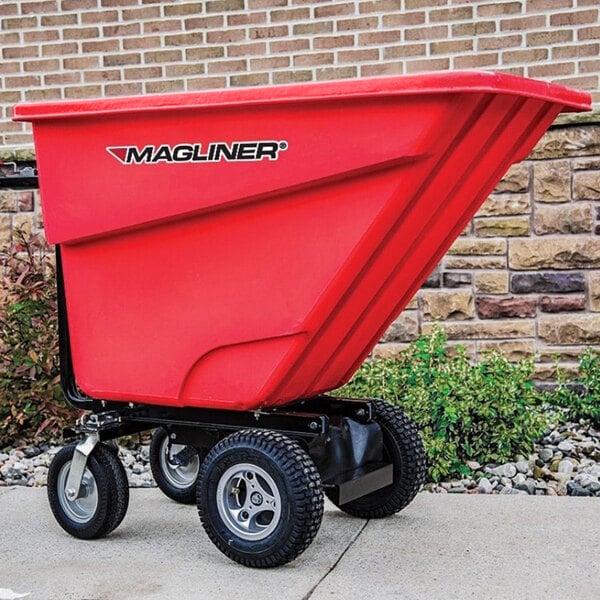 A red Magliner motorized hopper cart with wheels on a sidewalk.