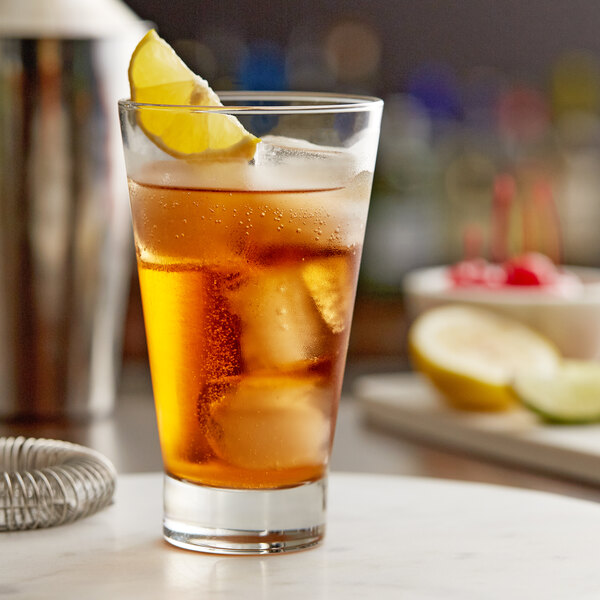 A Libbey highball glass filled with iced tea and a lemon wedge.