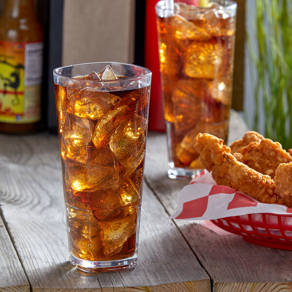 A Libbey plastic beverage glass with ice tea on a table with fried chicken.