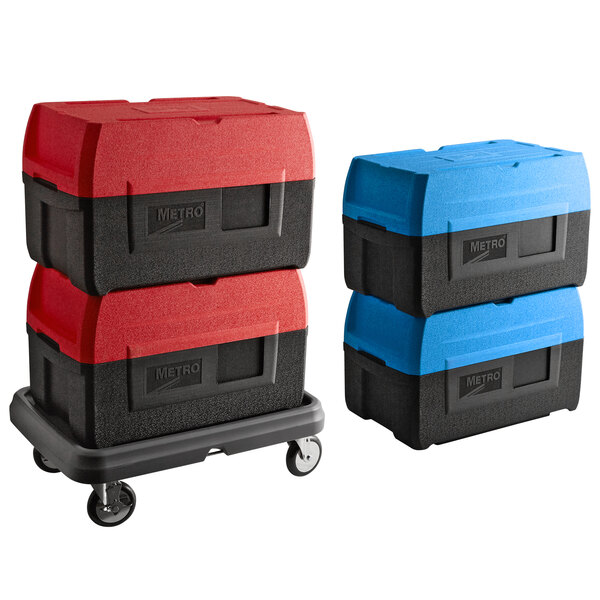 A dolly with four blue and black Metro Mightylite BigBoy food pan carriers.