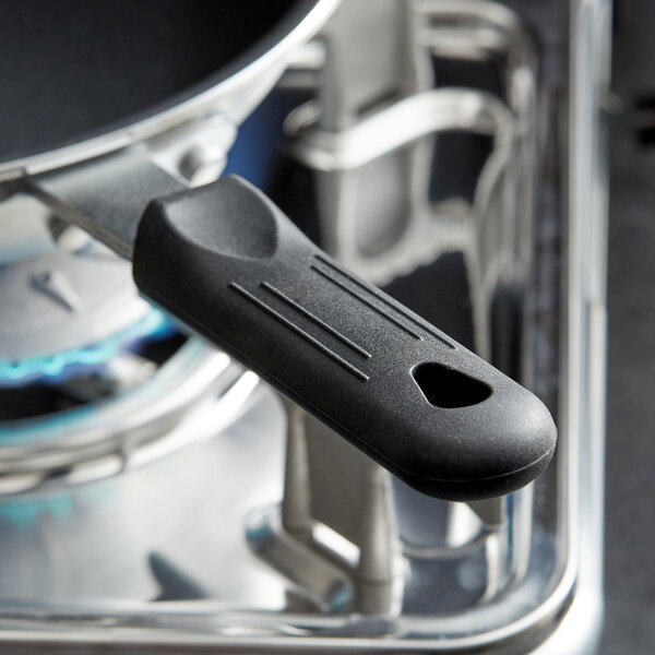 A close-up of a black Choice removable silicone pan handle sleeve on a pan handle.