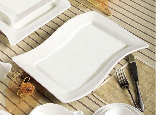 A CAC Soho ivory rectangular stoneware platter with a fork and knife on a table.