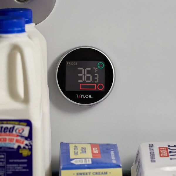 A Taylor digital refrigerator / freezer thermometer on a refrigerator shelf.