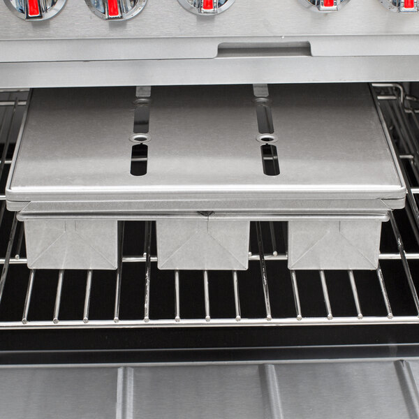 Two Chicago Metallic aluminized steel pullman pans on a metal shelf in an oven.