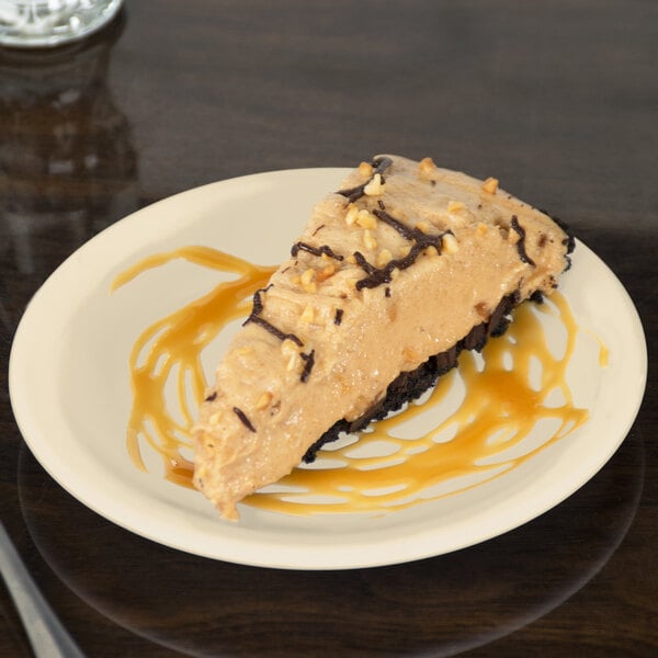 A Carlisle tan melamine plate with a slice of pie topped with chocolate.