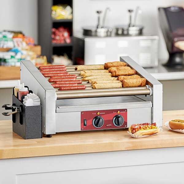 An Avantco slanted hot dog roller grill with hot dogs cooking on it.